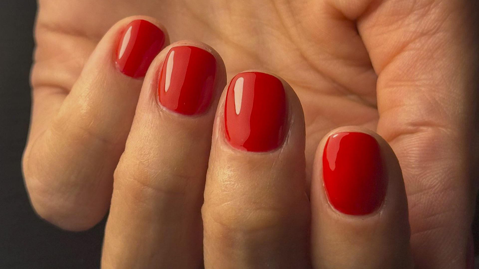 Bright and glossy red gel polish manicure with a strong, high-shine finish.