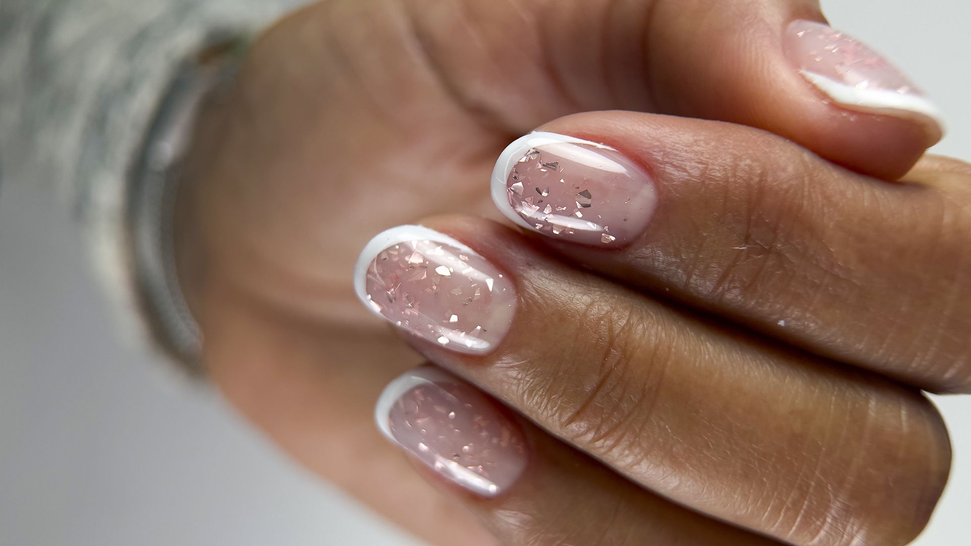 Hard gel nails with a transparent base, geometric fragments inside, and a classic white French tip line.